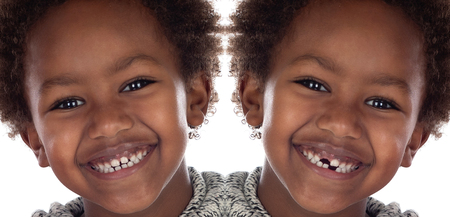 Two happy children with and without teeth laughing and looking at camera isolated on a white backgroundの写真素材