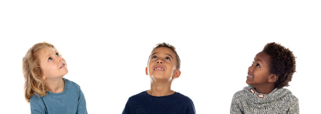 Three happy children looking up isolated on a white backroundの写真素材