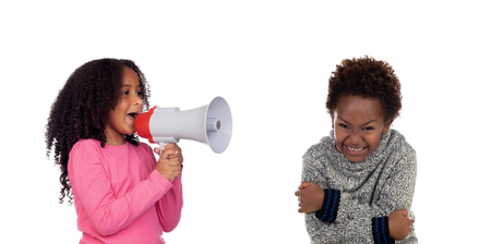 Funny childr shouting through a megaphone to his brother. Isolated on white backgroundの写真素材
