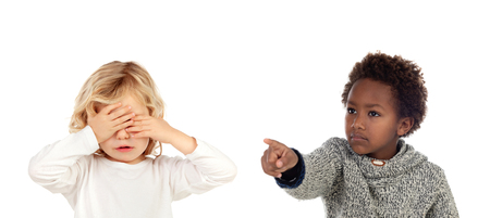 African child saying a order to his friend, who is covering the eyes isolated on a white backgroundの写真素材