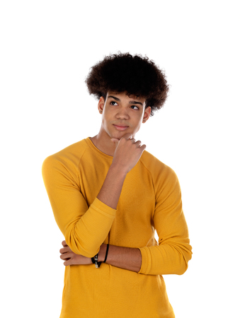 Pensive teenager boy wiht yellow t-shirt isolate on a white backgroundの写真素材