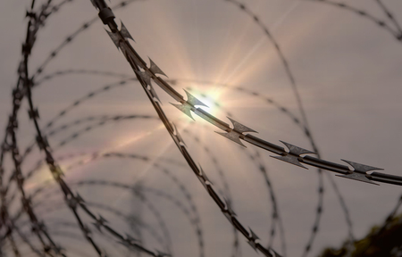 Fence with a barbed wire under a blue sky