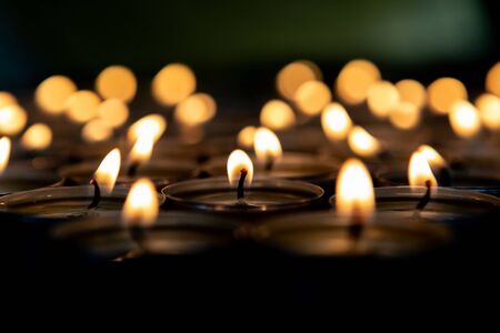 Many small burning candles on a wooden surfaceの写真素材