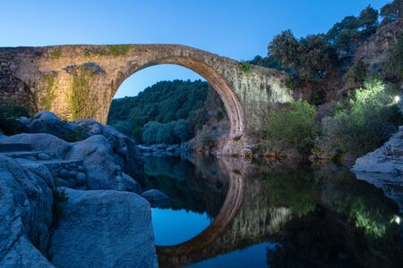 Beautiful stone bridge on a river at nightの写真素材