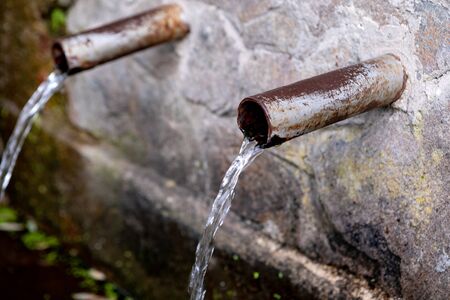 Source of two pipes with crystal clear water of the mountain