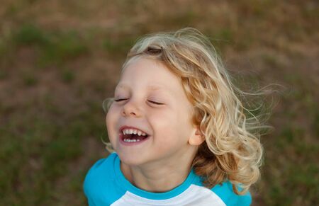 Small child with long blond hair enjoying of a sunny day