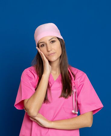 Young doctor with a pink uniform on a blue backgroundの写真素材