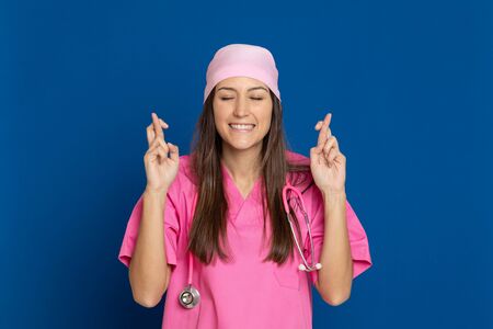 Young doctor with a pink uniform on a blue background