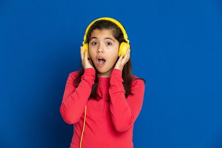 Adorable preteen girl with red jersey on a blue backgroundの写真素材
