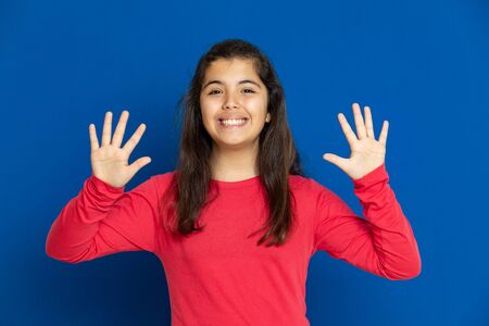 Adorable preteen girl with red t-shirt i on a blue background