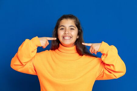 Adorable preteen girl with yellow jersey on a blue background