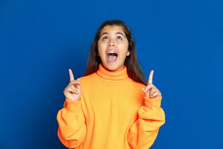 Adorable preteen girl with yellow jersey on a blue backgroundの写真素材