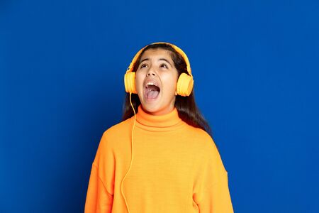 Adorable preteen girl with yellow jersey on a blue background