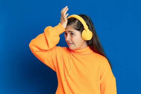 Adorable preteen girl with yellow jersey on a blue backgroundの写真素材