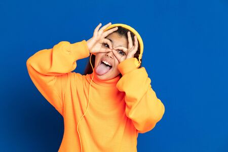 Adorable preteen girl with yellow jersey on a blue backgroundの写真素材