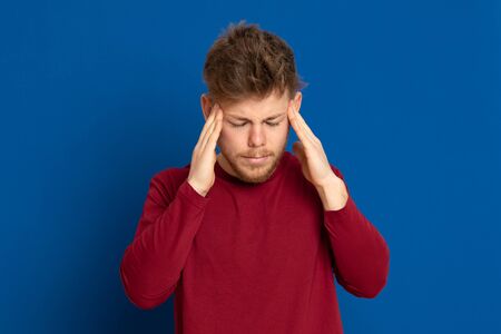 Attractive young guy with a red T-shirt on a blue background