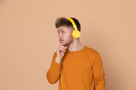 Attractive young guy on a yellow backgroundの写真素材
