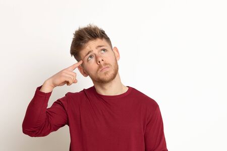 Attractive young guy with a red T-shirt isolated on a white backgroundの写真素材