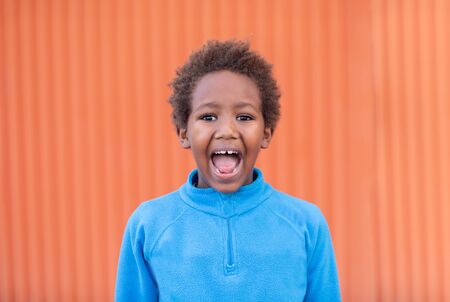 Funny african child with blue jersey and a colourful backgroundの写真素材