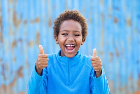 Excited african kid saying Ok with a blue jerseyの写真素材