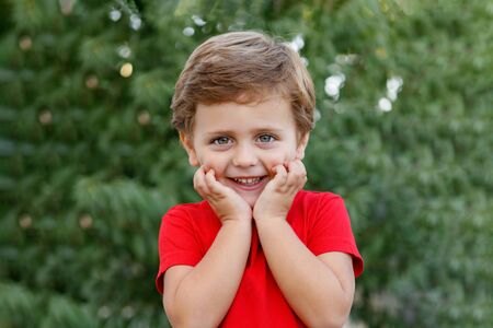 Happy child with red t-shirt playing in the gardenの写真素材