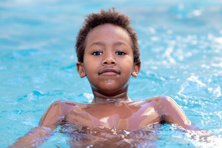 Little african child enjoying the summer in the pool の写真素材