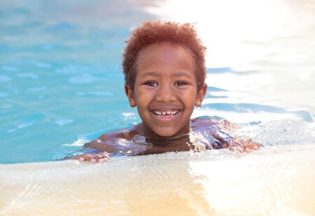 Little african child enjoying the summer in the pool の写真素材