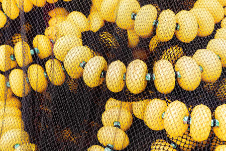 Fishing nets piled up in a small coastal harbor