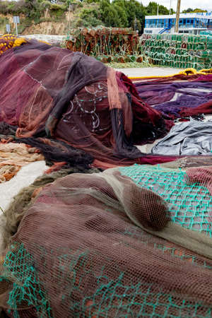 Fishing nets piled up in a small coastal harbor