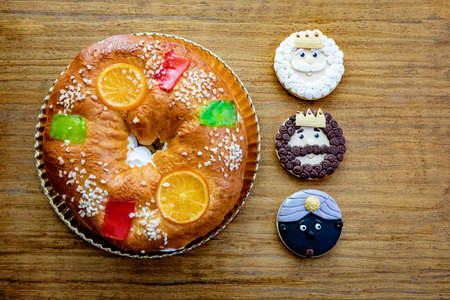 Cookies of The three Wise Man next to a delicious Spanish Christmas cake on a wooden backgroundの写真素材