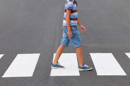 Child crossing the crosswalk on the roadの写真素材