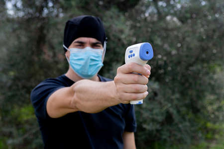 Doctor taking temperature with infrared thermometerの写真素材