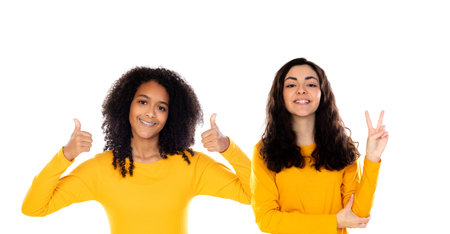 Two cheerful women friends girls in yellow clothes isolated on a white background