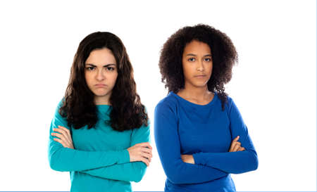 Two angry teenage girls wearing blue sweater isolated on a white background
