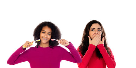 Teenager girls with tooth brushes isolated on a white backgroundの写真素材