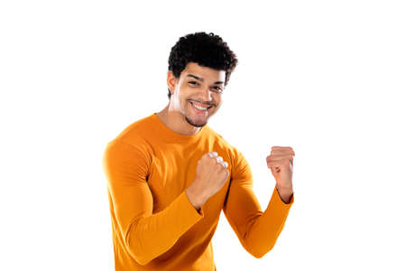 Cute african american man with afro hairstyle wearing an orange T-shirt isolated on a white...