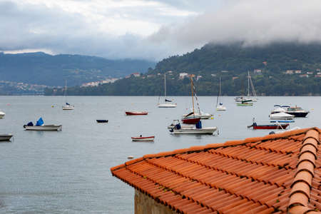 Amazing view of the sea with boats and a roof in the foregroundの写真素材