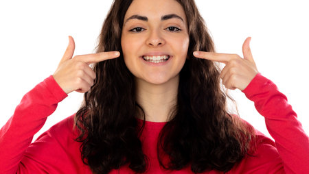Young brunette woman smiling cheerful showing and pointing with fingers teeth and mouth.Dental...