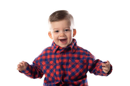 Little baby boy in stylish casual clothing smiling over white wall background
