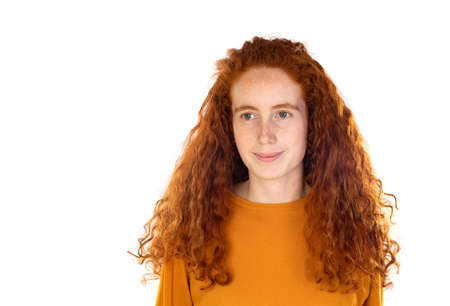 Pretty redhead young woman with long wavy hair and freckles wears t-shirt feels satisfied and looks confident isolated over white backgroundの写真素材