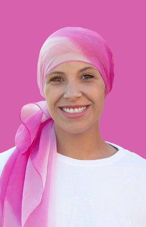 Hopeful woman wearing a headscarf on a pink backgroundの写真素材