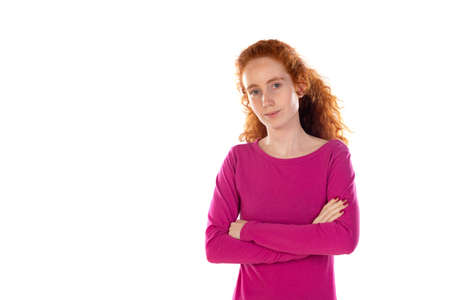 Redhaired young woman wearing a pink t-shirt isolated on a white background