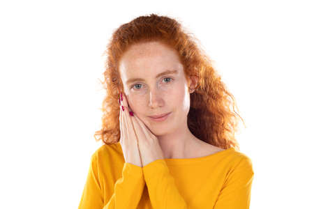 Young redhead woman wearing casual clothes sleeping tired dreaming and posing with hands together...