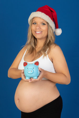Pregnancy. Happy pregnant woman isolated on a blue backgroundの写真素材
