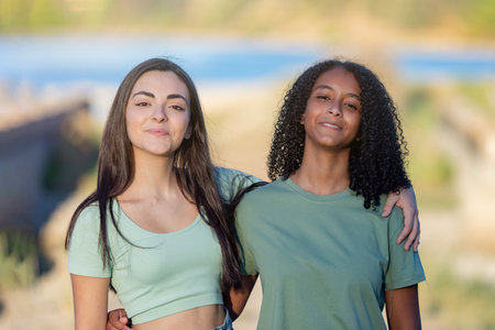 Two girls friends in the countryside walking near a river on a sunny dayの写真素材
