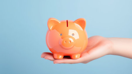 Holding a piggy bank against a soft blue backdrop with one hand by Generative AIの素材