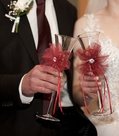  Bride and groom hold champagne in glasses for a toastの写真素材