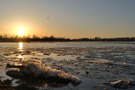  Ice drift on the river and sunset, ice floes floating on the water, spring april melts the ice...