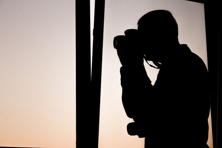 Silhouette photograph with purple sky background. Camera ready to shoot photos. Photograph.の写真素材