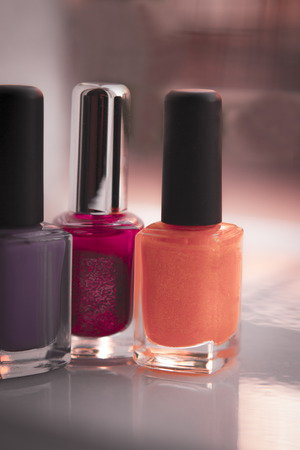 Close up of red, lilac and yellow nail polish  isolated.の写真素材